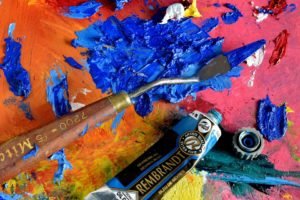 A surface with spilled paint and used painting tools