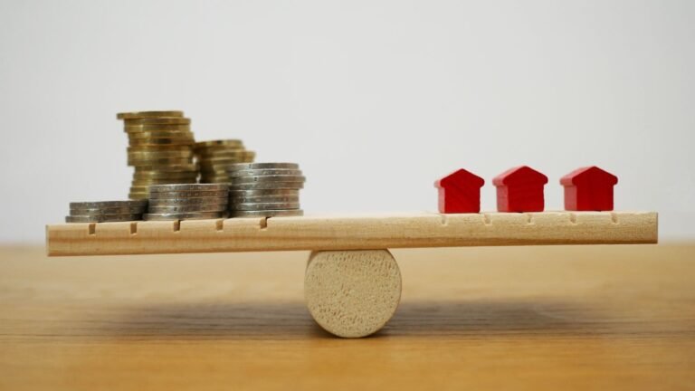 Money and houses balanced on what seems like a wooden scale - sunk costs