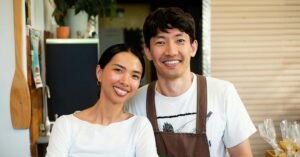 Smiling small business owners standing together inside their shop